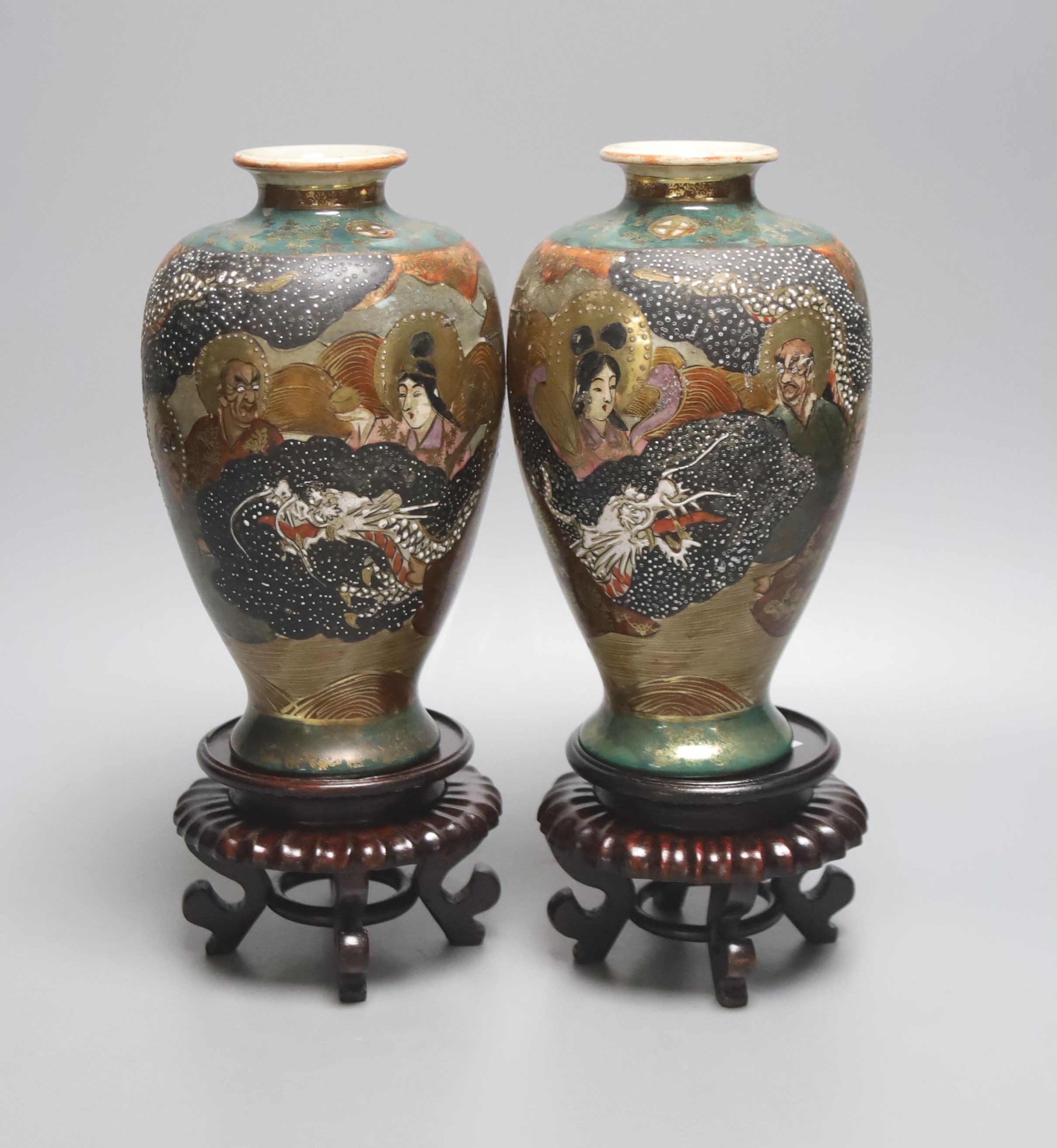 A pair of Japanese Satsuma pottery vases, depicting immortals, 17.5cm, wood stands